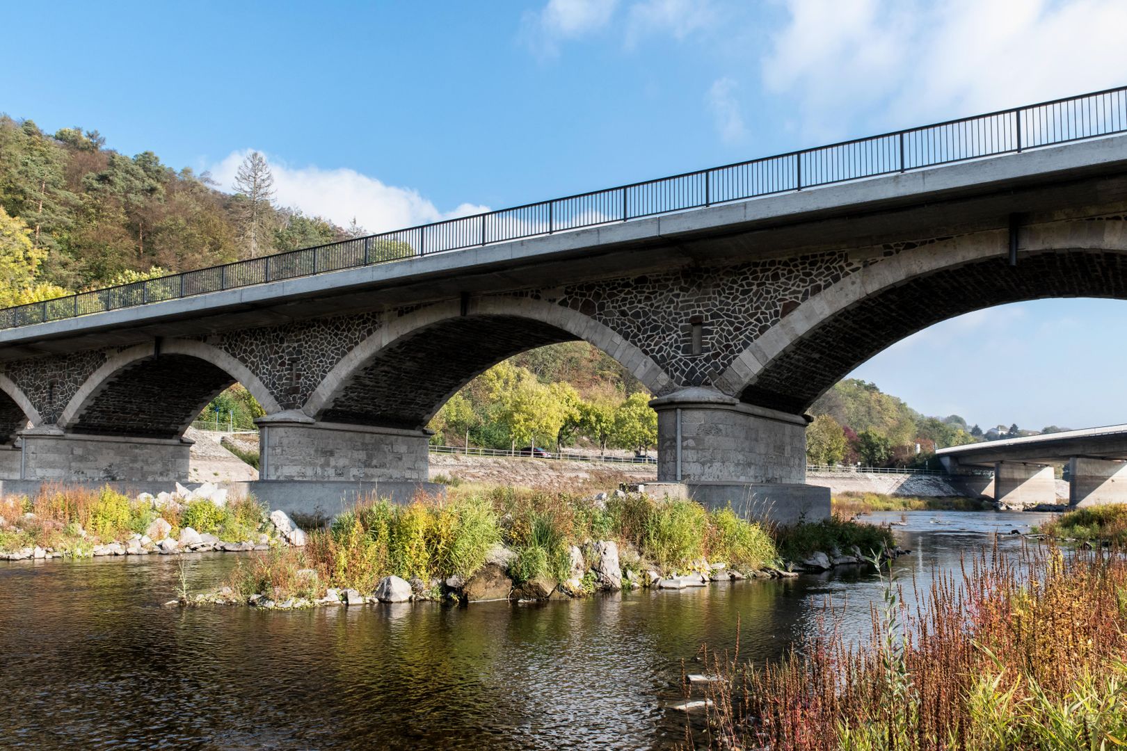 Elevated highway viaduct curving through forested mountain landscape
